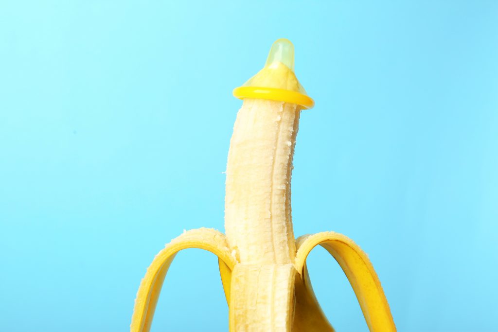 Condom,On,Banana,Against,Color,Background.,Safe,Sex,Concept